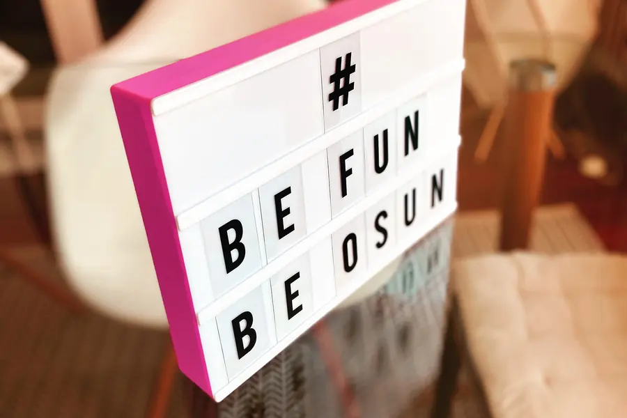 Enseigne lumineuse affichant « Be fun, be OSUN » dans les locaux de l’agence.